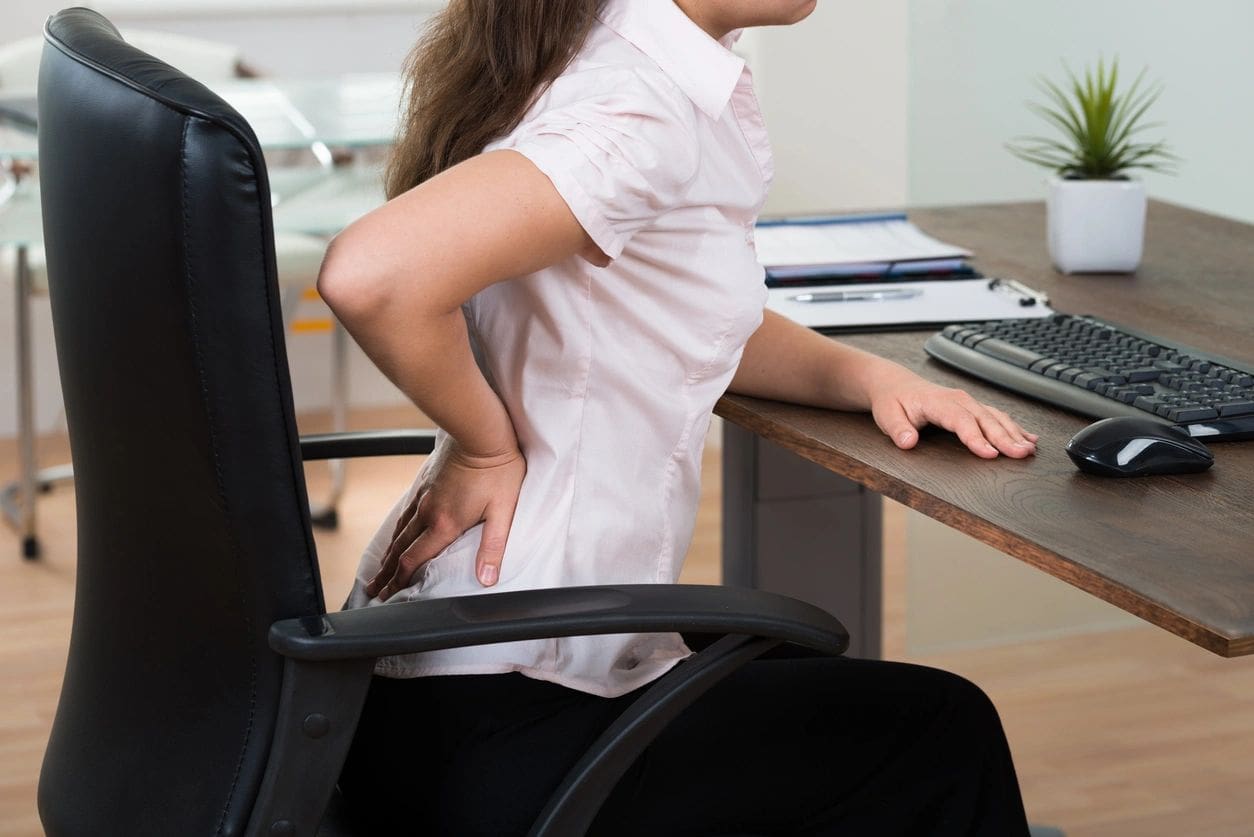 A woman sitting at the desk with her back turned.